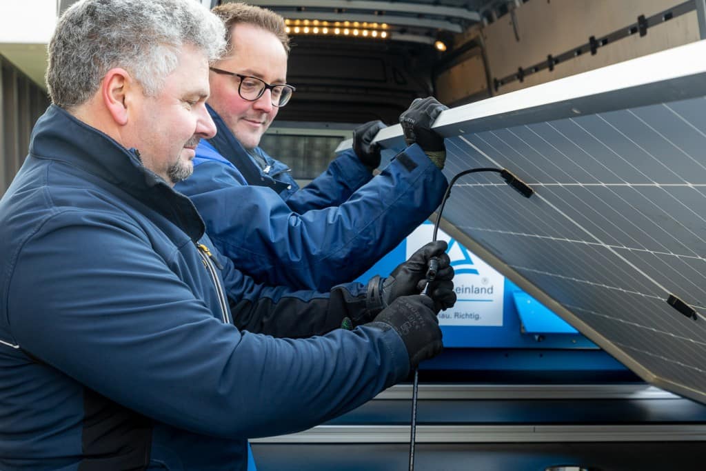 Industriefotografie TÜV Rheinland - Zwei Männer montieren das Solarpanel