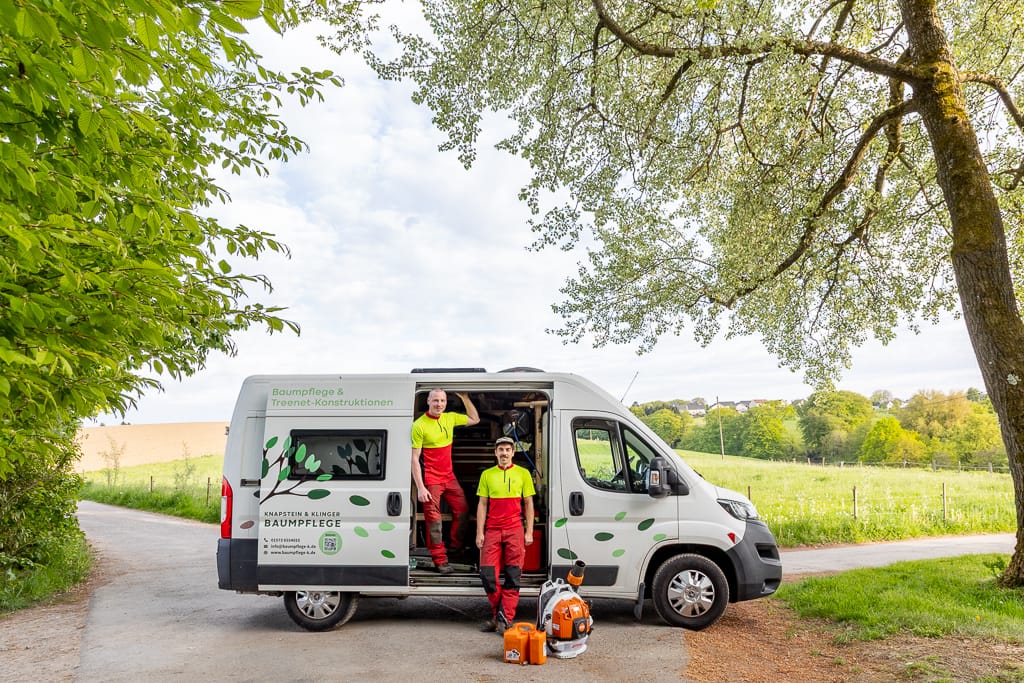 Firmenporträt vor dem Firmenwagen