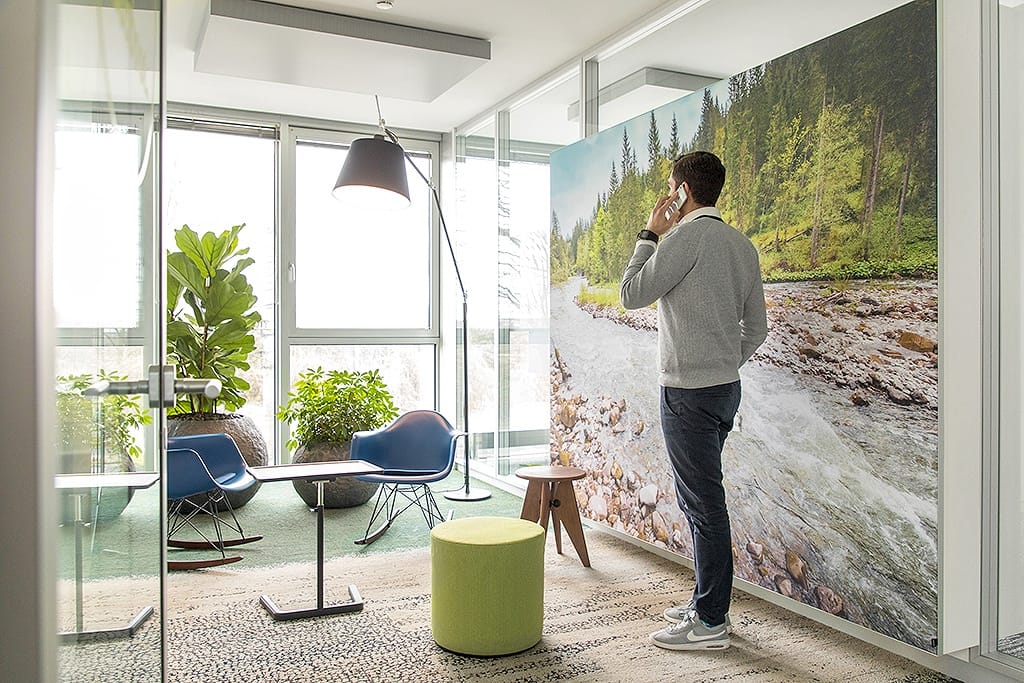 Businessfotografie für die Rheinlandversicherung. Ein Mann steht am Fenster und telefoniert. Das Büro ist modern.