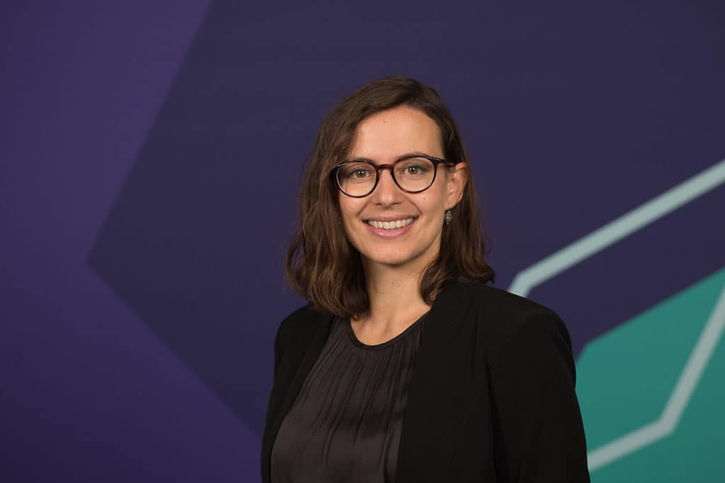 Fotograf Köln Mitarbeiterportraits - Manfred Daams fotogarfierte für YOUGOV Deutschland über 100 Mitarbeiter im Kölner Büro direkt am Rhein. Zu sehen ist eine Frau vor einem blauen Hintergrund.