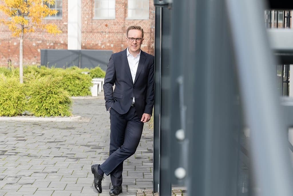 Shooting eines Mannes mit herbstfarbenen Bäumen im Hintergrund.