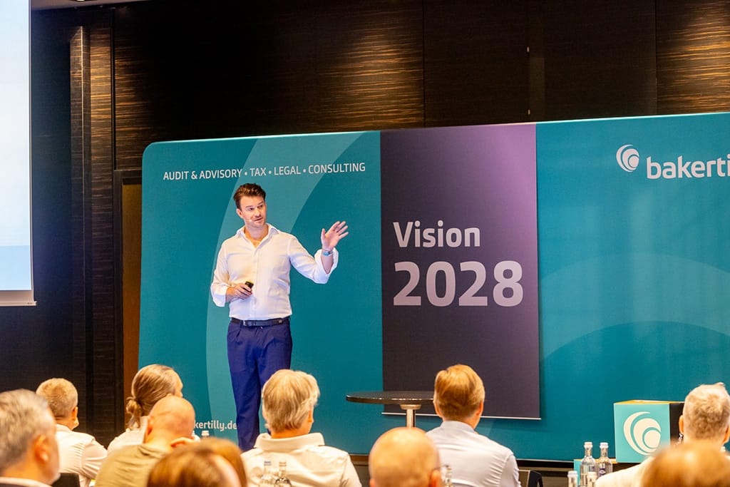 Eventfotografie Köln - Keynote-Speaker auf der Baker Tilly Veranstaltung, die wichtige Geschäftsinformationen teilen