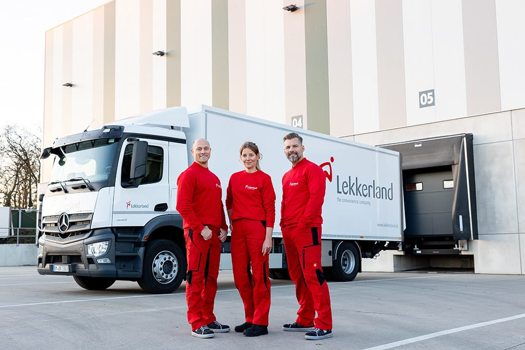 Drei Personen vor einem Lieferwagen.