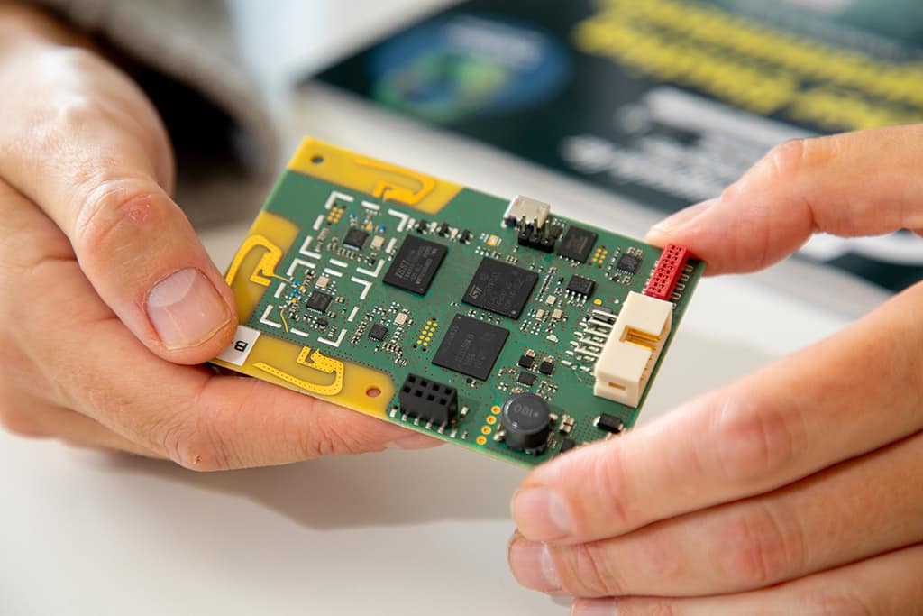 Firmenportät - Ein Mann hält einen Chip in der Hand.