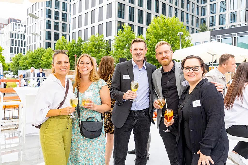 Ein Fotograf dokumentiert ein Event mit lebhaften Tanzbewegungen und lachenden Teilnehmern.