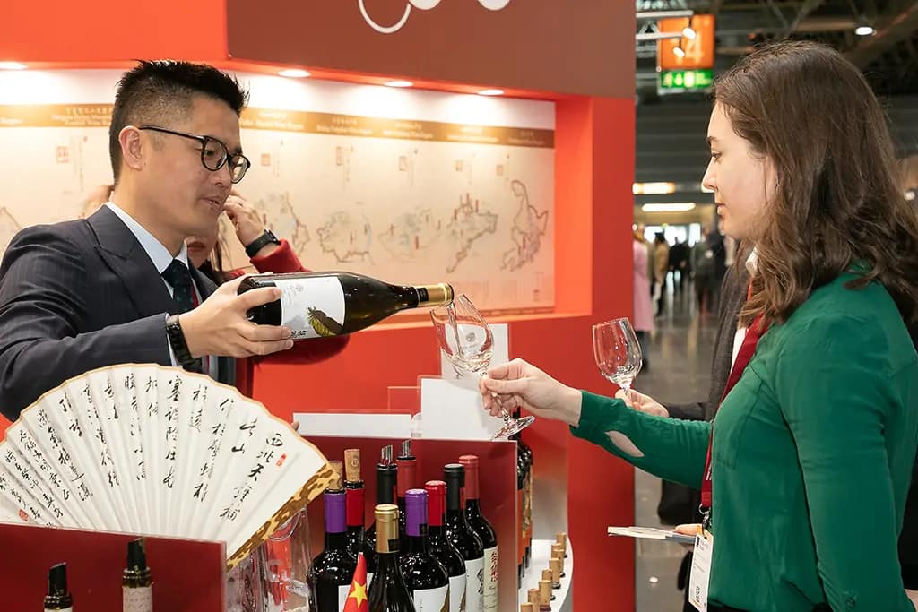 Ein Mann schenkt Wein ein - Messefotografie auf der ProWEIN