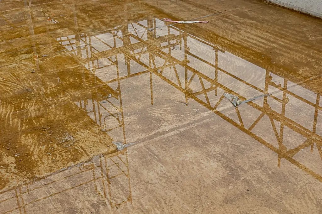 Spiegelung der Baustelle in einer Pfütze