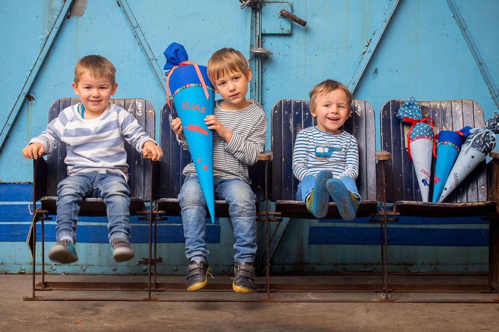 Kinder sitzen auf Kinosesseln und lachen in die Kamera