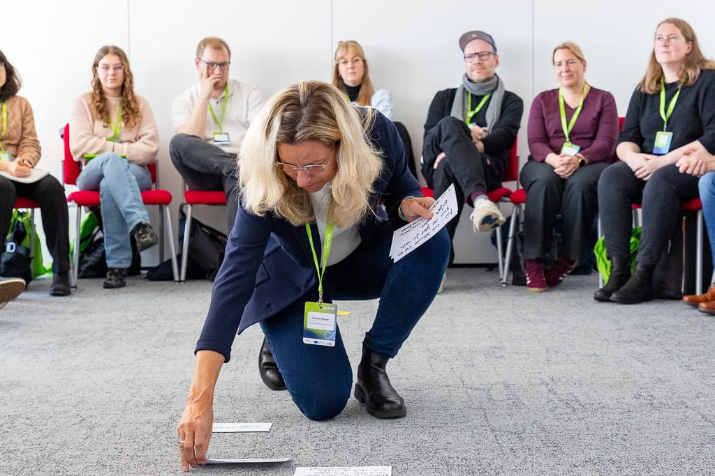 Ein Speaker legt eine Karte auf den Boden