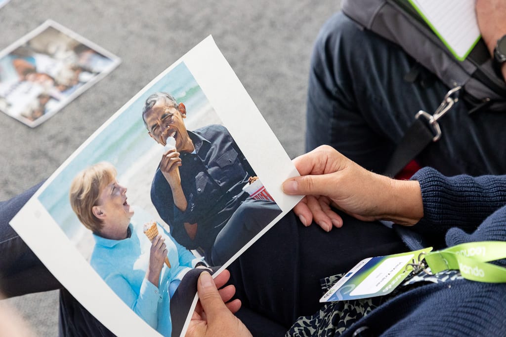KI Unterscheidung. Teilnehmer haben Bilder in der Hand und prüfen diese auf Echtheit