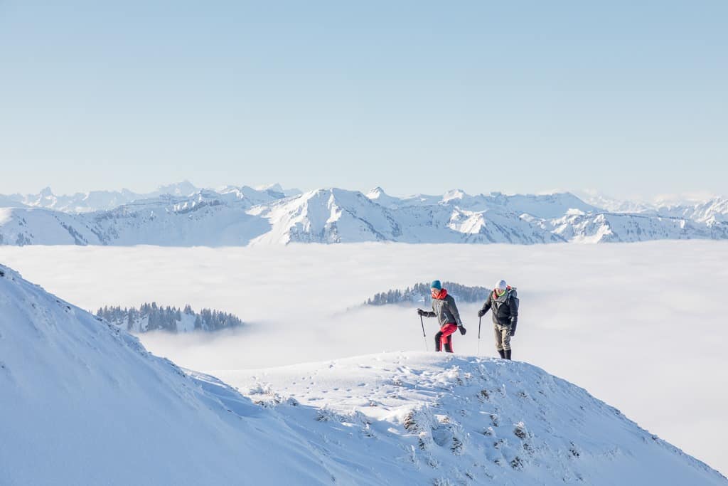 Hochgrad - Zwei Menschen beim Skifahren. Im Hintergrund sieht man die Berge. Reisefotos