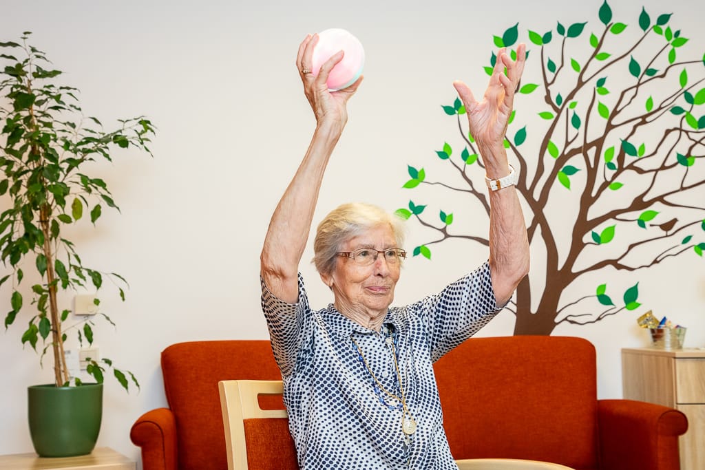 Eine Seniorin hält den Icho Ball in der Hand