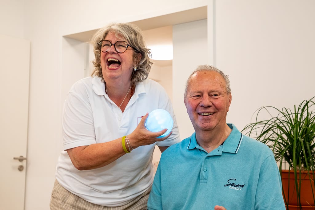 Eine Pflegerin hat mit dem Partienten Spaß