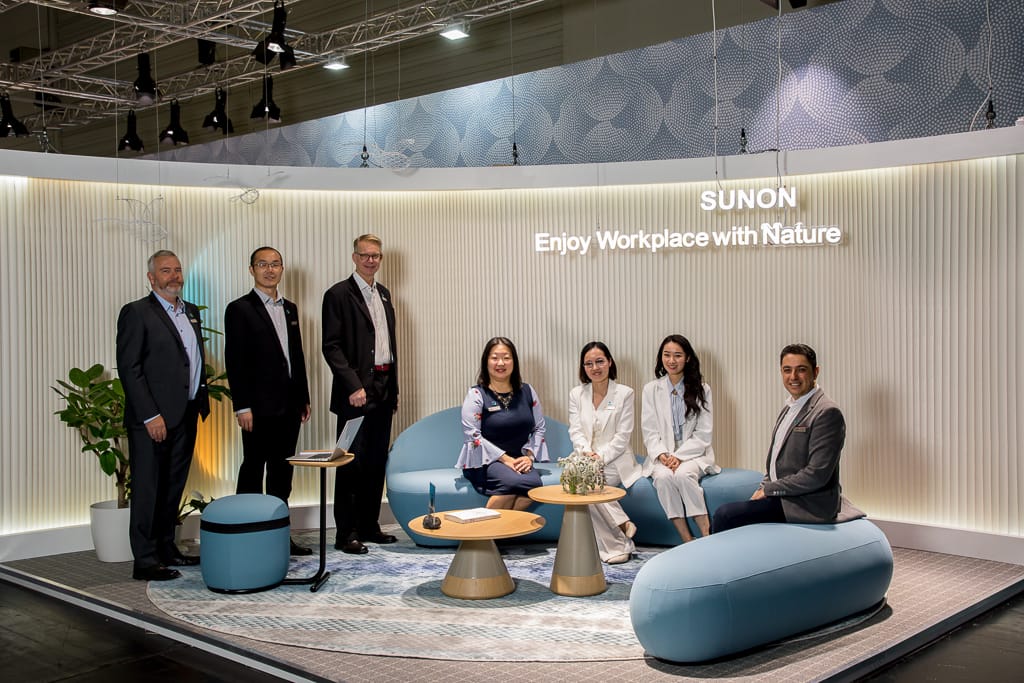 Gruppenfoto auf dem Messestand von Sunon. Menschen schauen in die Kamera