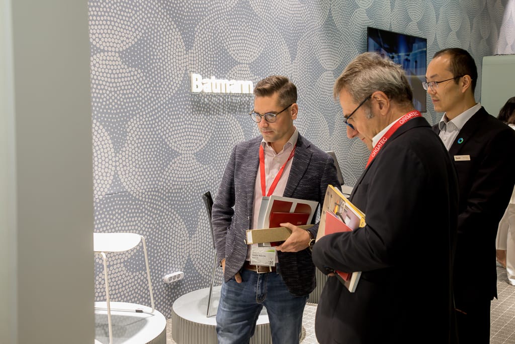 Menschen diskutieren vor einem Messestand