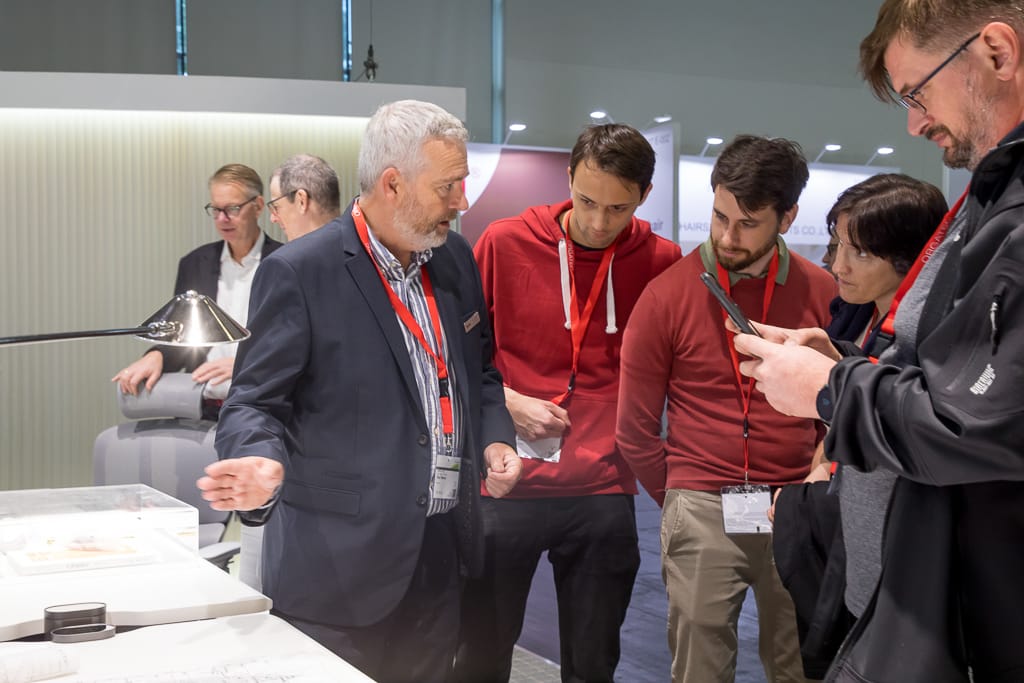 Menschen diskutieren vor einem Messestand