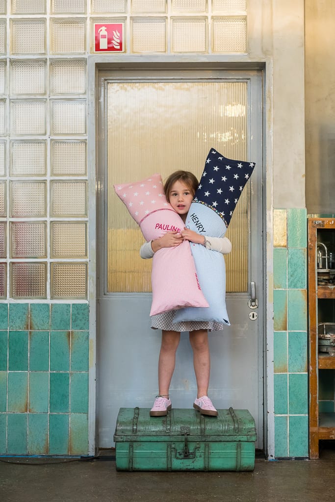 Business Fotograf Köln - Ein Kind hält zwei selbstgemachte Kissen in der Hand