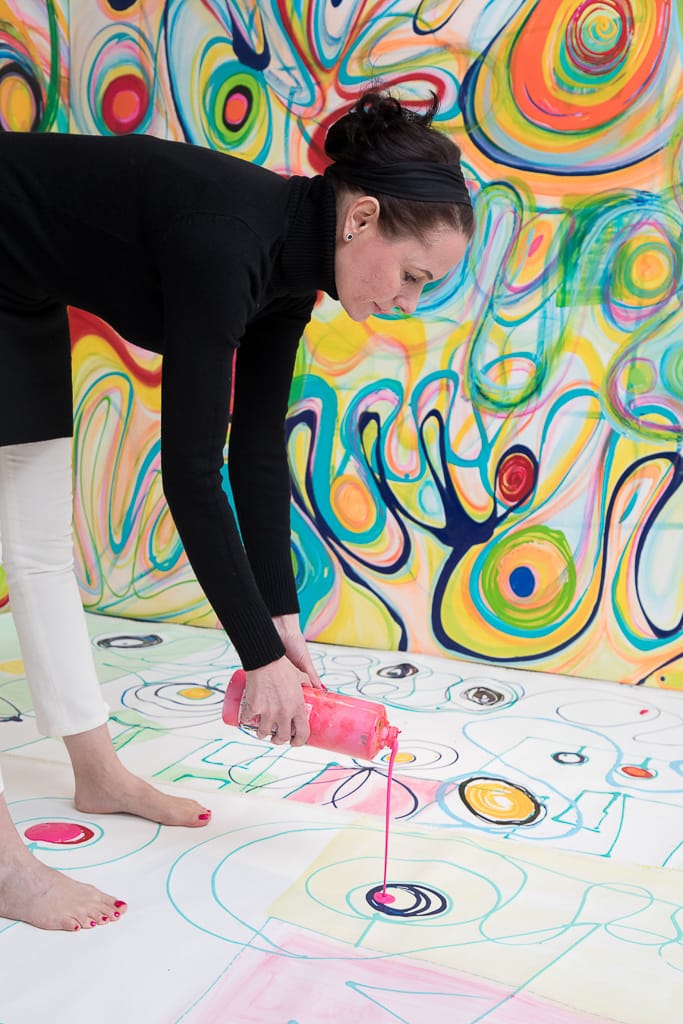 Closeup Aufnahme - die Künstlerin lässt Farbe auf eine Leinwand aus